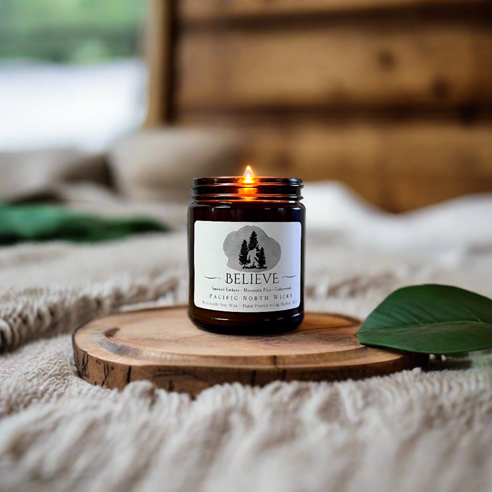 Bigfoot gift candle lit in cozy log cabin bedroom set in the forest of the PNW