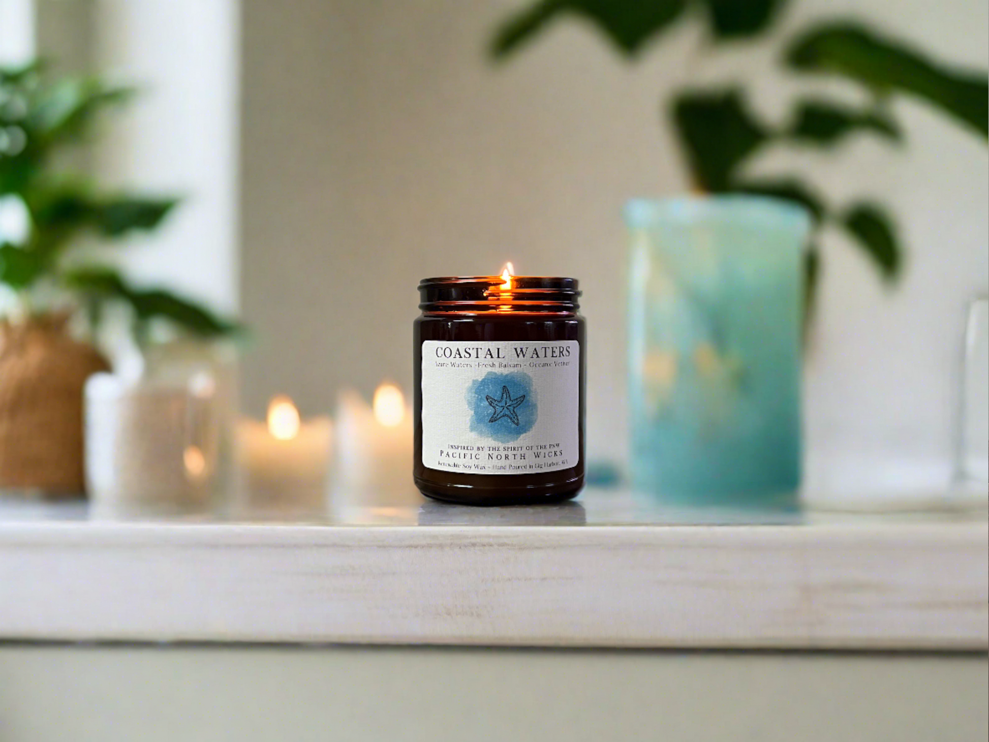 Ocean Candle lit in modern Coastal Home with beach themed decor and greenery.