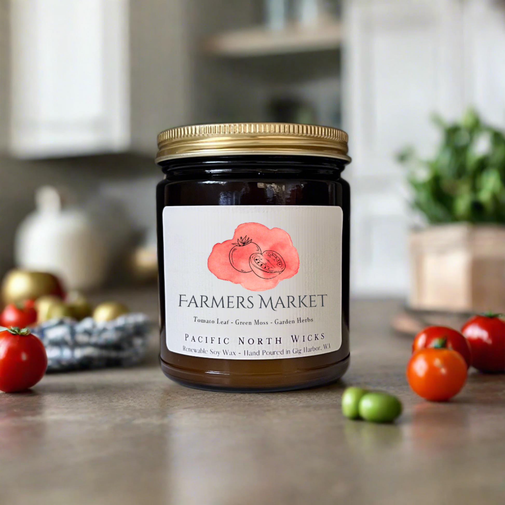 Farmers Market candle in amber jar with gold lid.  Label indicates scent notes of tomato leaf, green moss, and garden herbs.