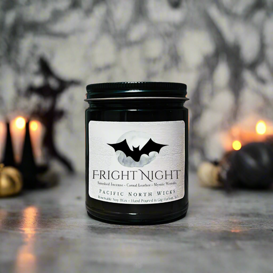 Fright Night Candle with spooky Halloween decor in background including black pumpkins and witches