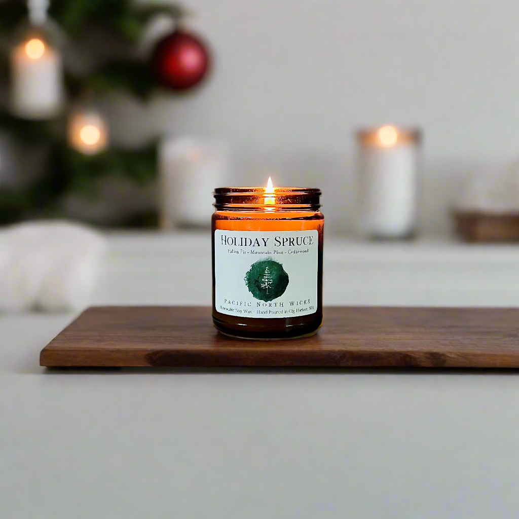 Holiday Spruce candle in minimalist modern setting on marble countertop with ornaments in background.