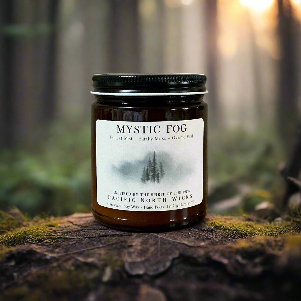 Mystic Fog candle in forest setting with dappled sunlight and fog through the trees.
