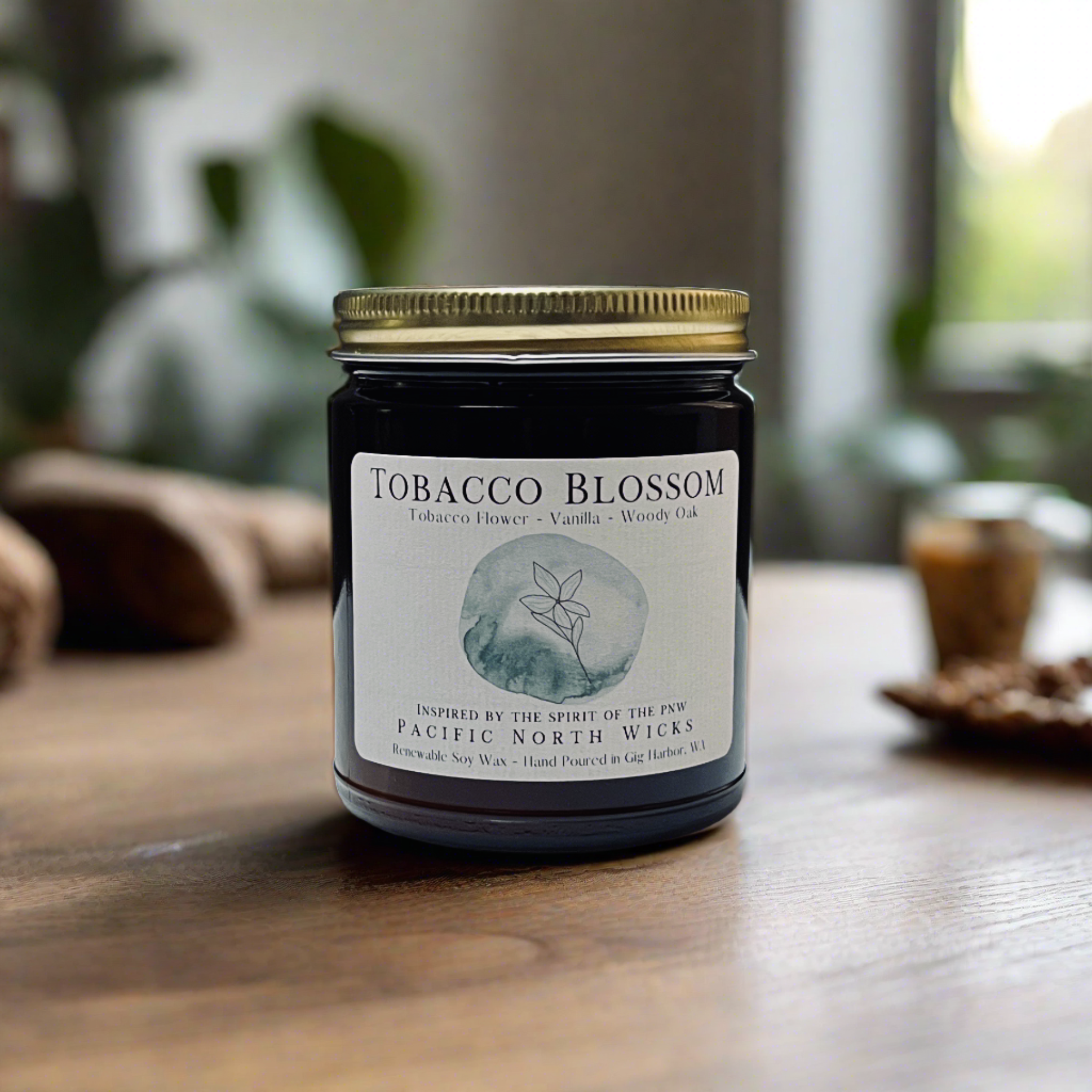 Tobacco vanilla scented candle in amber jar with gold lid.