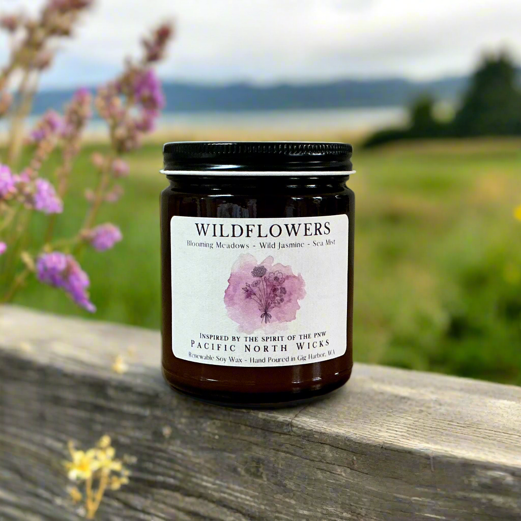 Amber jar floral candle with black metal lid.  Scent notes of blooming meadows, wild jasmine, and sea mist.