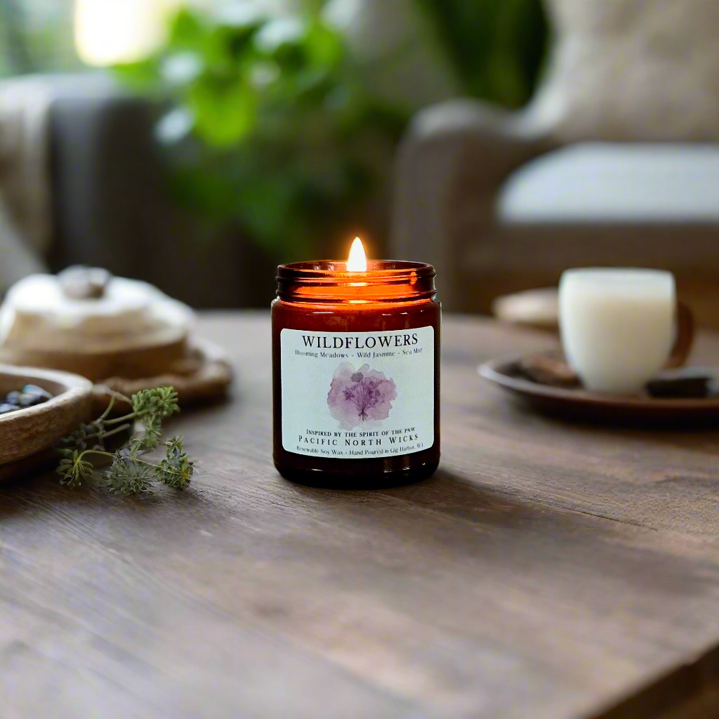 Wildflowers candle burning on rustic coffee table in boho living room setting.