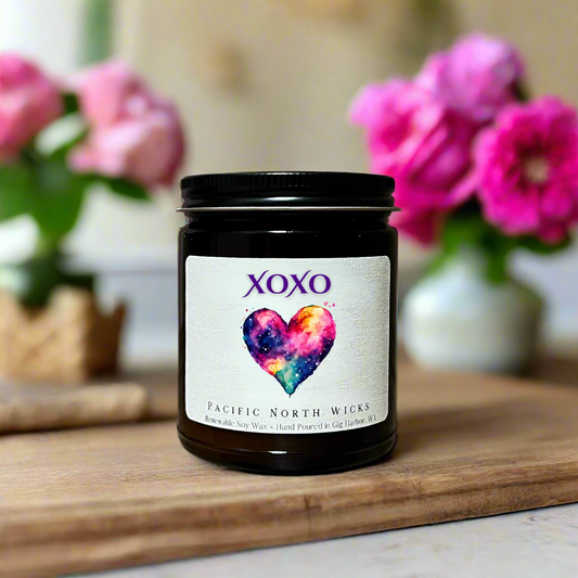 XOXO Valentine's Day Gift Candle in setting with pink flowers and petals