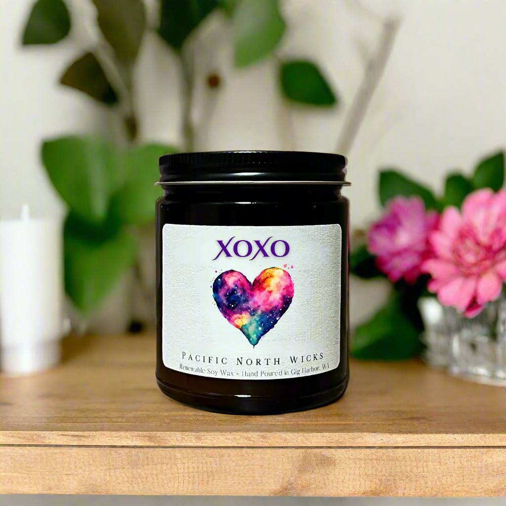 XOXO Candle Gift in bohemian setting with plants and flowers in background